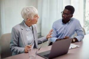 African American entrepreneur talking his business mentor on a meeting in the office.