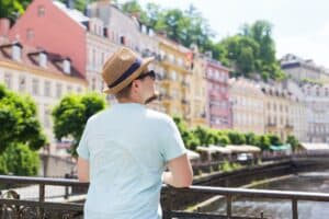 Back view of happy stylish tourist on Czech Republic. Handsome man travelling in Europe